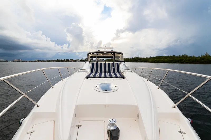 Slide: The Image of 2004 Regal 4260 Commodore yacht on calm waters under a cloudy sky. - 13