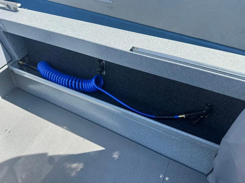 Slide: The Image of KingFisher 2025 Escape boat storage compartment with blue coiled hose, 2024 model. - 24