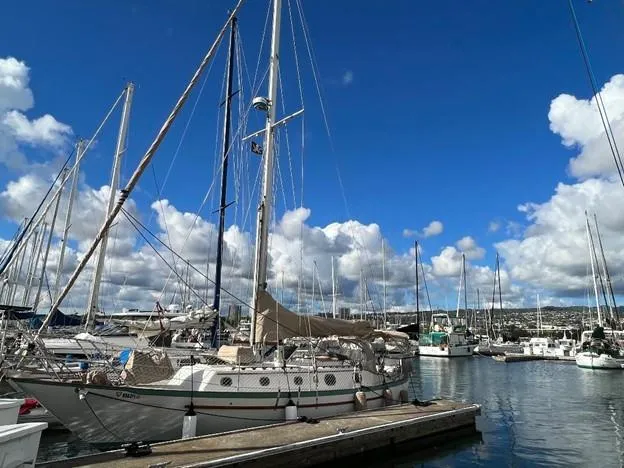 Slide: The Image of 1986 Pacific Seacraft 37 sailboat docked at a marina under a blue sky. - 1