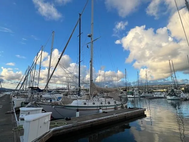Slide: The Image of 1986 Pacific Seacraft 37 sailboat docked at a marina under a blue sky with clouds. - 3
