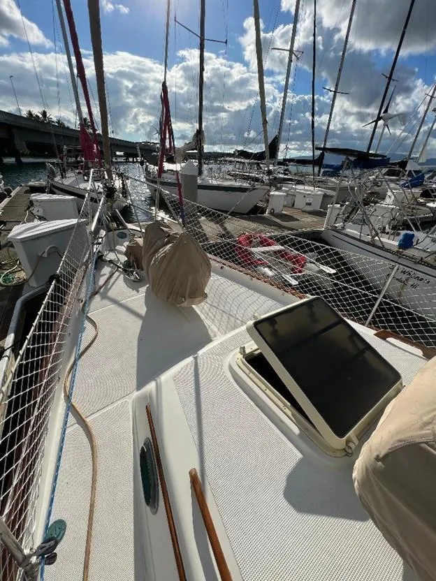 Slide: The Image of 1986 Pacific Seacraft 37 sailboat docked at a marina under a partly cloudy sky. - 6