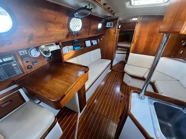 Slide: The Image of 1986 Pacific Seacraft 37 interior with wooden finishes and white seating. - 9