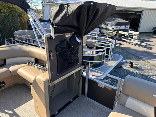 Slide: The Image of 2024 Starcraft LX 20 CB pontoon boat interior with beige seating and storage compartments. - 6