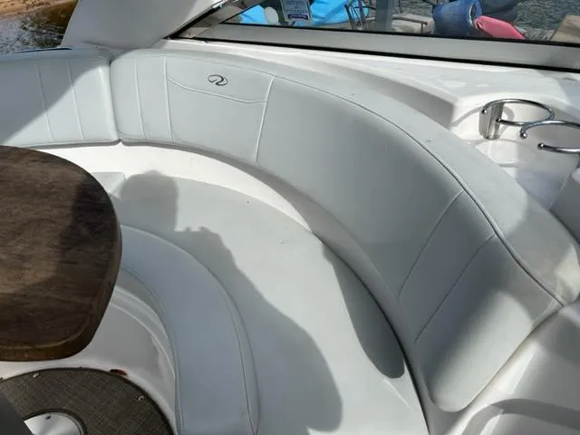 Slide: The Image of 2010 Regal 3060 Window Express boat interior with white seating and wooden table. - 11