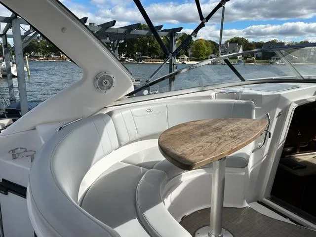 Slide: The Image of 2010 Regal 3060 Window Express boat interior with curved seating and wooden table. - 15