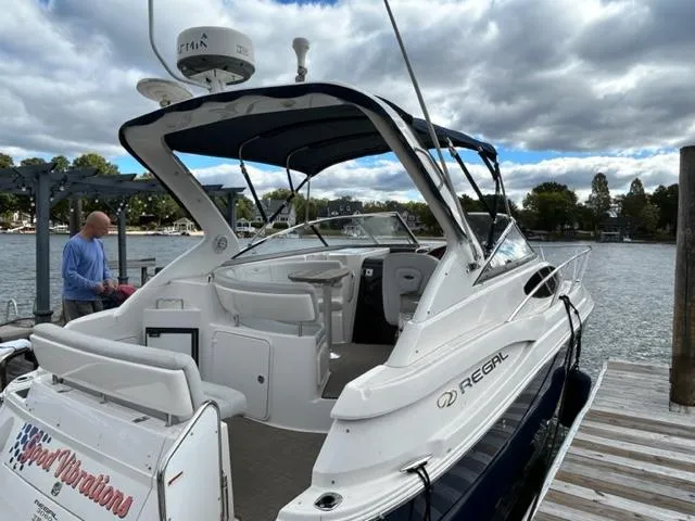 Slide: The Image of 2010 Regal 3060 Window Express boat docked at a marina under cloudy skies. - 2