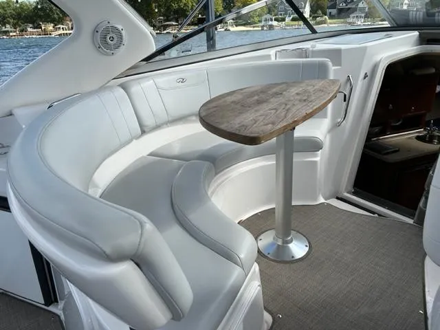 Slide: The Image of 2010 Regal 3060 Window Express boat interior with curved seating and wooden table. - 24