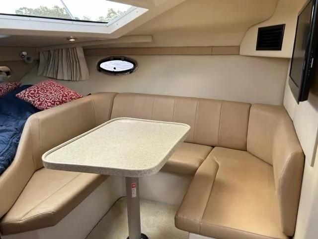 Slide: The Image of 2010 Regal 3060 Window Express cabin interior with beige seating and table. - 30