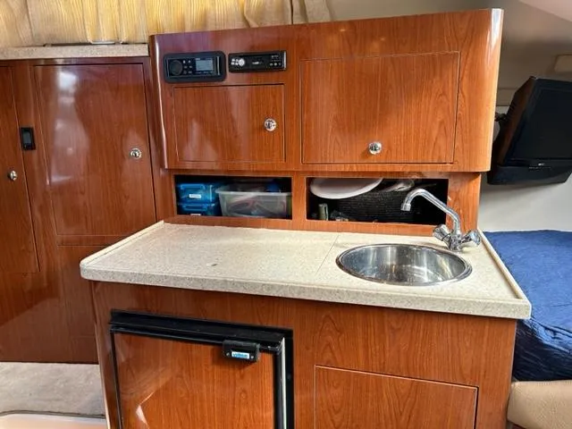 Slide: The Image of 2010 Regal 3060 Window Express boat interior with kitchenette, sink, and storage cabinets. - 37