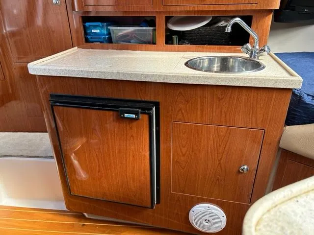 Slide: The Image of 2010 Regal 3060 Window Express boat kitchenette with sink, mini-fridge, and storage cabinets. - 39