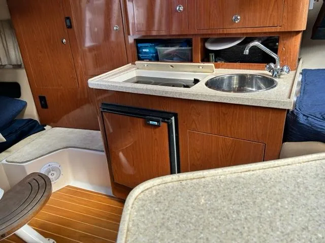 Slide: The Image of 2010 Regal 3060 Window Express boat interior with kitchenette and wooden cabinetry. - 41