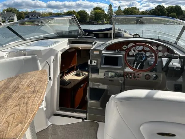 Slide: The Image of 2010 Regal 3060 Window Express boat interior with helm, seating, and cabin access. - 6