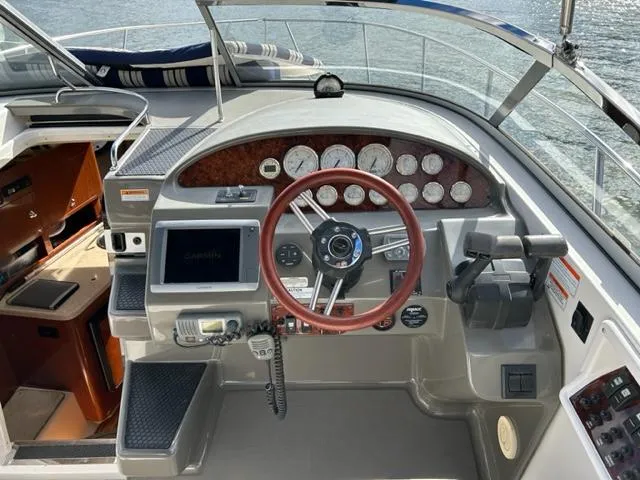 Slide: The Image of 2010 Regal 3060 Window Express boat helm with steering wheel, gauges, and navigation equipment. - 7