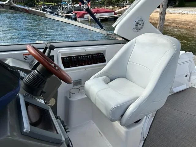 Slide: The Image of 2010 Regal 3060 Window Express boat helm with white captain's chair and wooden steering wheel. - 8
