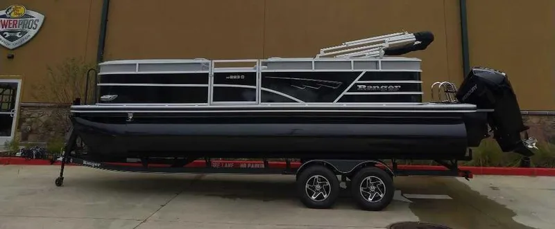 Slide: The Image of 2024 Ranger Reata 223C pontoon boat on a trailer. - 0