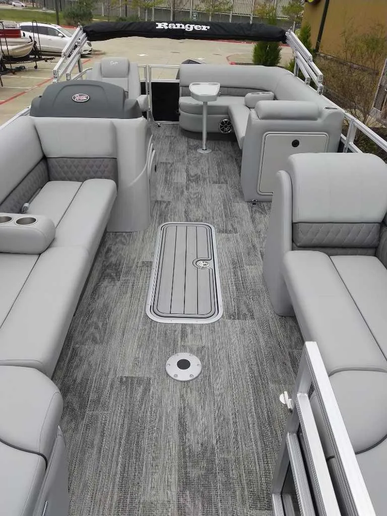 Slide: The Image of 2024 Ranger Reata 223C pontoon boat with spacious gray seating and modern flooring. - 18