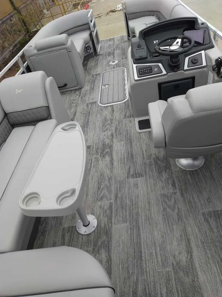Slide: The Image of 2024 Ranger Reata 223C boat interior with gray seating and modern helm. - 20