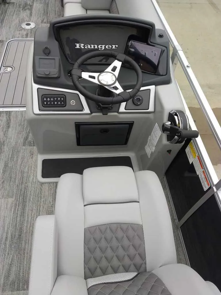 Slide: The Image of 2024 Ranger Reata 223C boat console with steering wheel and control panel. - 22