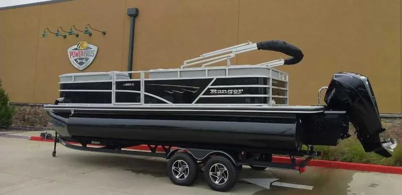 Slide: The Image of 2024 Ranger Reata 223C pontoon boat on a trailer outside a dealership. - 3