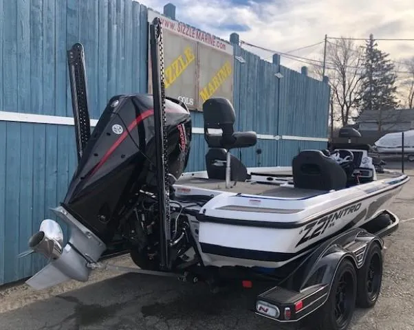 Slide: The Image of 2022 Nitro Z21 XL boat with powerful outboard motor, parked near blue fence. - 6