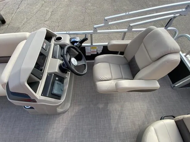 Slide: The Image of 2024 Sun Tracker Party Barge 18 DLX helm station with captain's chair and steering wheel. - 12