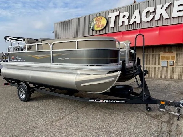 Slide: The Image of 2024 Sun Tracker Party Barge 18 DLX pontoon boat on trailer outside Bass Pro Shops. - 2