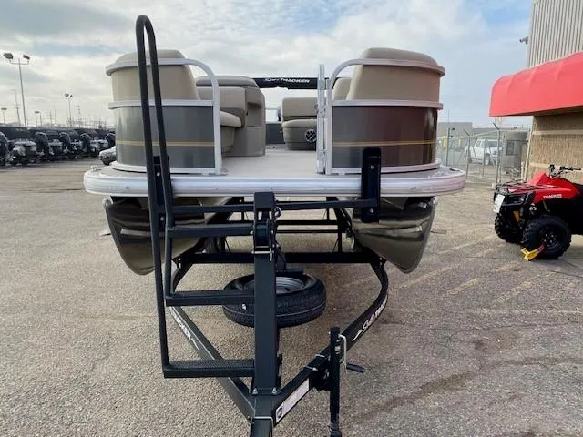 Slide: The Image of 2024 Sun Tracker Party Barge 18 DLX pontoon boat on a trailer, front view. - 6