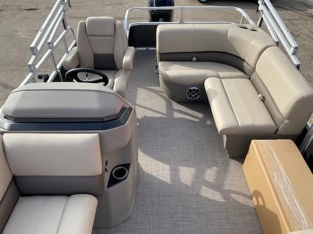 Slide: The Image of 2024 Sun Tracker Party Barge 18 DLX interior with beige seating and steering console. - 9