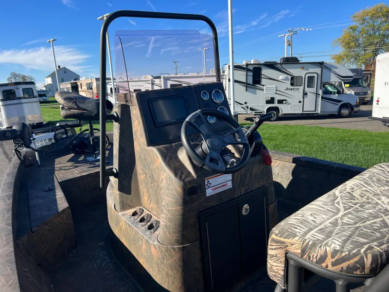 Slide: The Image of 2021 G3 Bay 20 DLX boat interior with steering console and camo seats. - 6