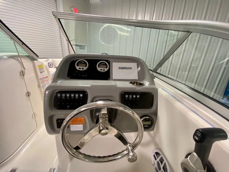 Slide: The Image of 2024 Robalo R207 Dual Console boat dashboard with steering wheel and Simrad display. - 13