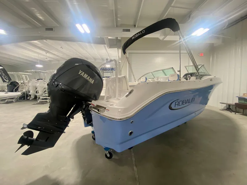 Slide: The Image of 2024 Robalo R207 Dual Console boat with Yamaha outboard motor in showroom. - 2