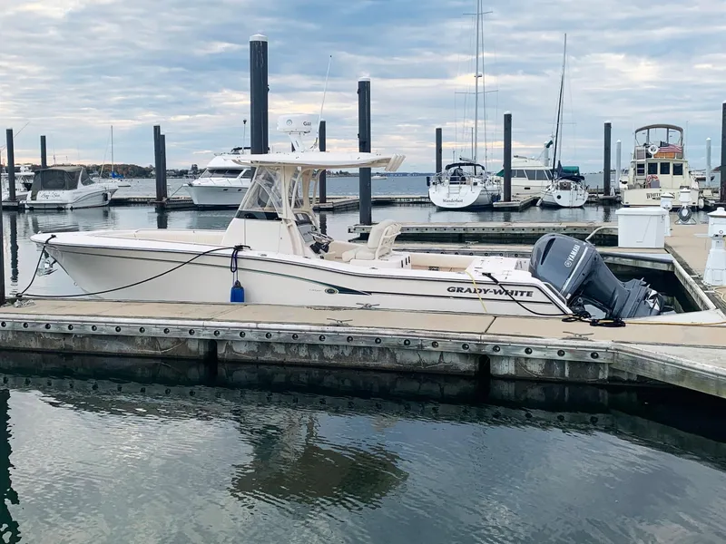 Slide: The Image of 2013 Grady-White Canyon 271 boat docked at a marina with other boats. - 1