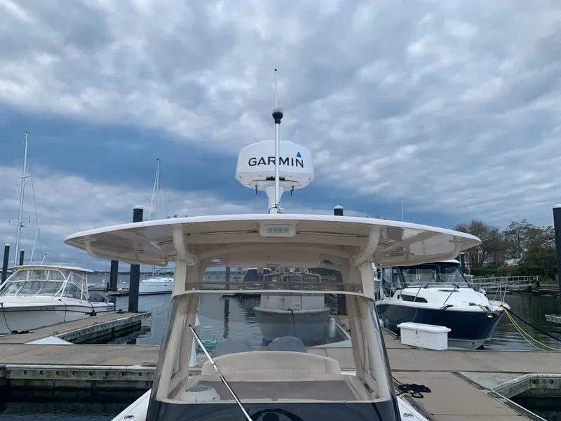 Slide: The Image of 2013 Grady-White Canyon 271 boat docked at a marina under cloudy skies. - 17