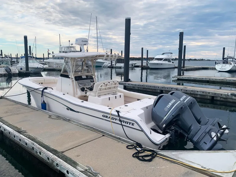 Slide: The Image of 2013 Grady-White Canyon 271 boat docked at marina with Yamaha outboard motor. - 2