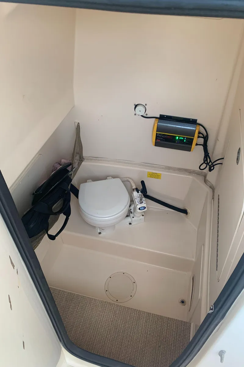 Slide: The Image of 2013 Grady-White Canyon 271 boat interior with marine toilet and equipment. - 22