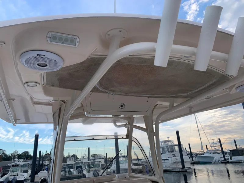 Slide: The Image of 2013 Grady-White Canyon 271 boat at marina, showing overhead console and rod holders. - 33