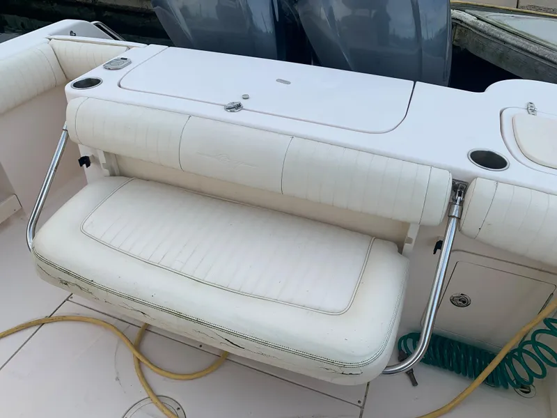 Slide: The Image of 2013 Grady-White Canyon 271 boat with white cushioned seating and storage compartments. - 8