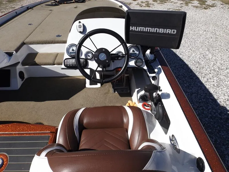 Slide: The Image of 2017 Legend V21 boat cockpit with Humminbird fishfinder, steering wheel, and brown leather seat. - 18