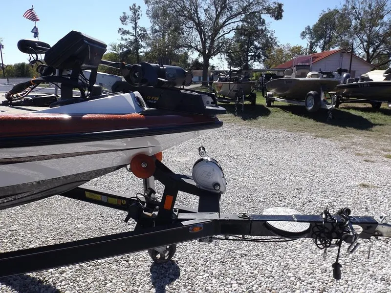 Slide: The Image of Legend V21 2017 boat on a trailer in a gravel lot with other boats. - 6