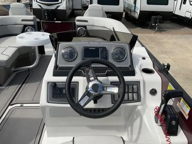 Slide: The Image of 2023 Hurricane FD2260F boat dashboard with steering wheel and control panel. - 2