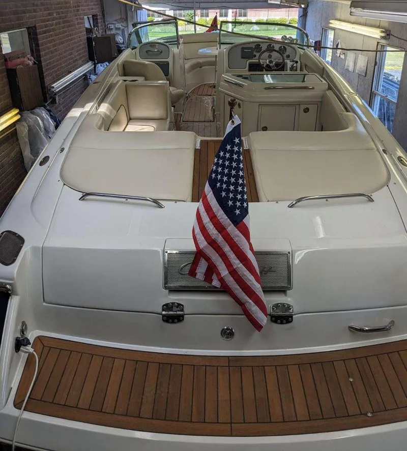 Slide: The Image of 2005 Chris-Craft Launch 28 boat with American flag, docked indoors. - 6