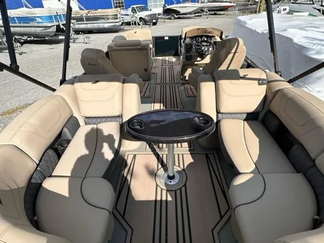 Slide: The Image of 2024 Starcraft SLS-3 pontoon boat interior with beige seating and central table. - 2