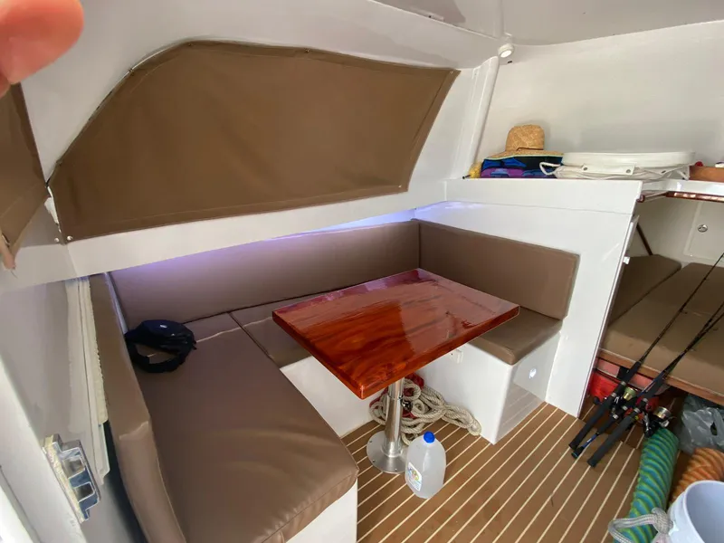Slide: The Image of 1973 Bertram 31 interior with cozy seating, wooden table, and fishing gear. - 4