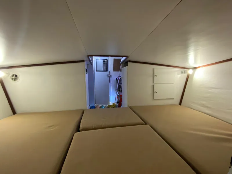 Slide: The Image of Interior cabin of a 1973 Bertram 31 boat with beige cushions and soft lighting. - 7