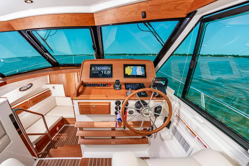 Slide: The Image of 2025 Back Cove 39O yacht helm with wooden accents and navigation screens. - 19