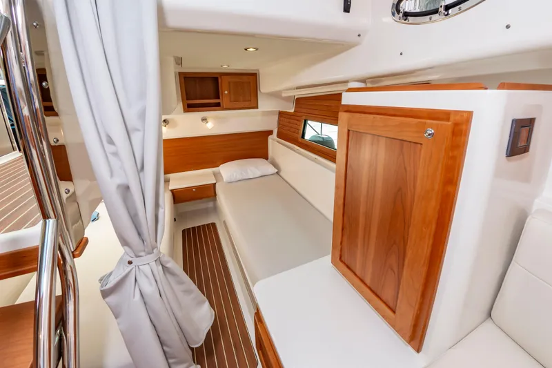 Slide: The Image of 2025 Back Cove 39O cabin interior with wooden accents and cozy sleeping area. - 32
