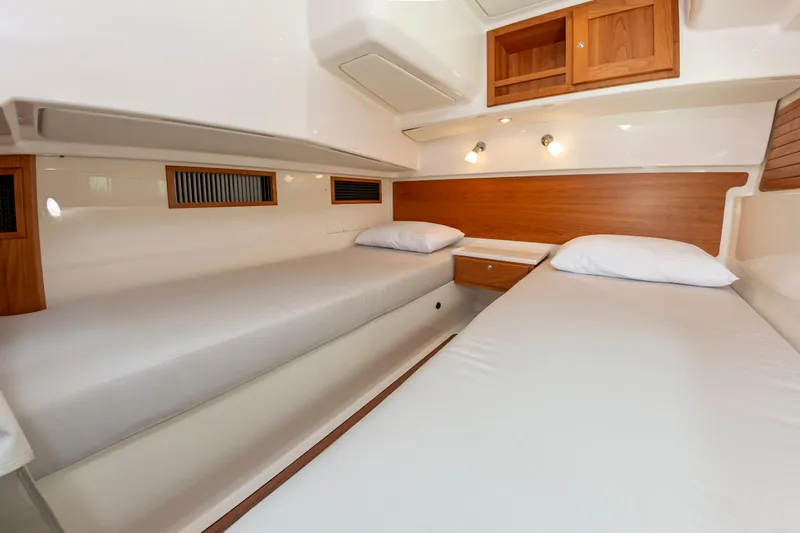 Slide: The Image of 2025 Back Cove 39O cabin interior with twin beds and wooden accents. - 33