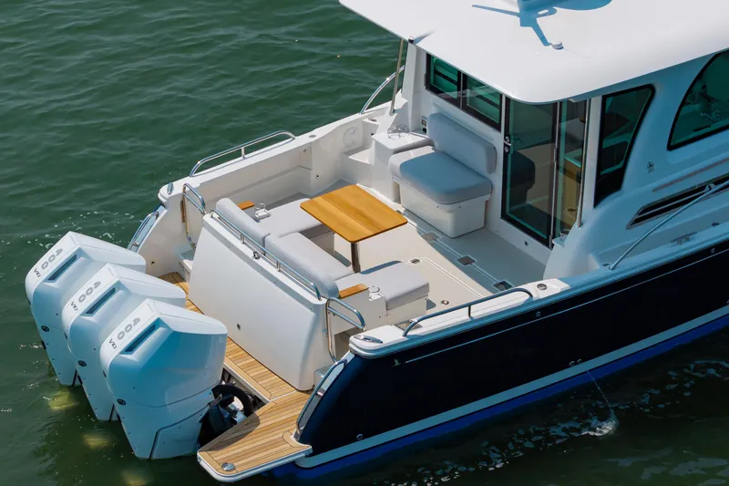Slide: The Image of 2025 Back Cove 39O boat with triple outboard engines, spacious deck, and seating area. - 5