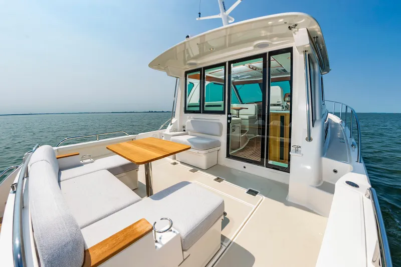 Slide: The Image of 2025 Back Cove 39O yacht with spacious deck and seating, cruising on calm waters. - 8