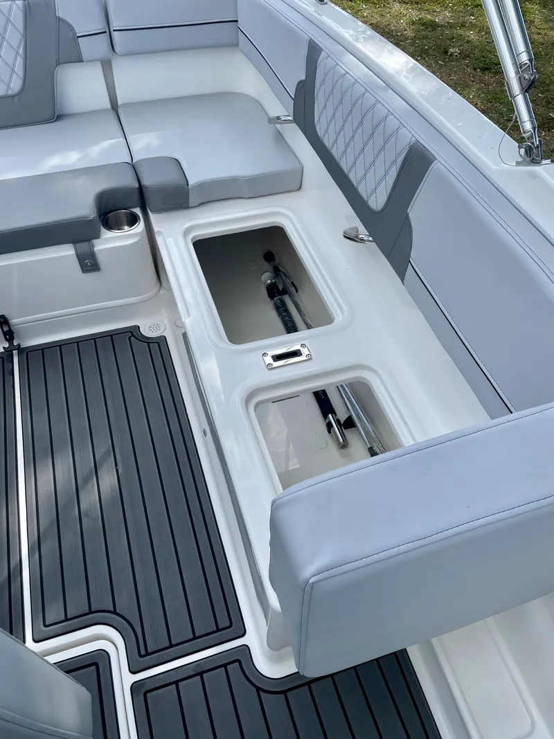 Slide: The Image of 2024 Bayliner VR4 boat interior with open storage compartments and cushioned seating. - 14
